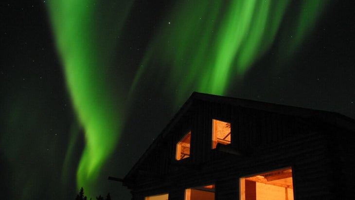 Two swirling green bands of aurora over Aurora Borealis Lodge in Fairbanks, Alaska