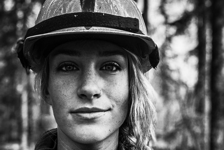 A woman firefighter with a helmet on.