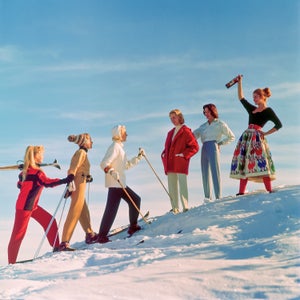 A group of ladies welcome their friends back from a day's skiing, with an apres ski drink.