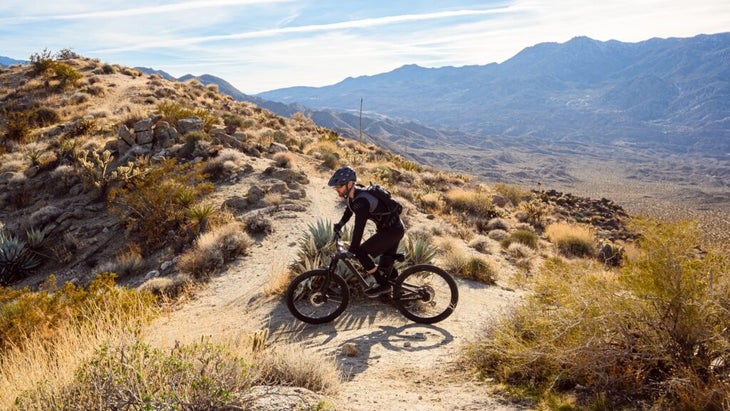 mountain biker wearing a helmet arrives at a ridgetop in Loma Linda, California