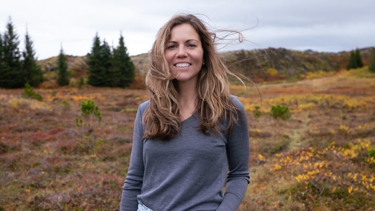 The author wearing a gray sweater and standing amid a tundra setting