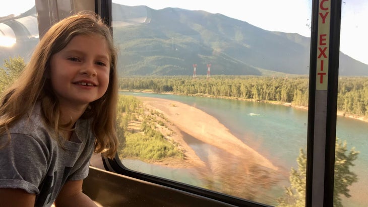 Evan Carson riding with mountain landscape behind her on the Empire Builder train from Chicago to Seattle