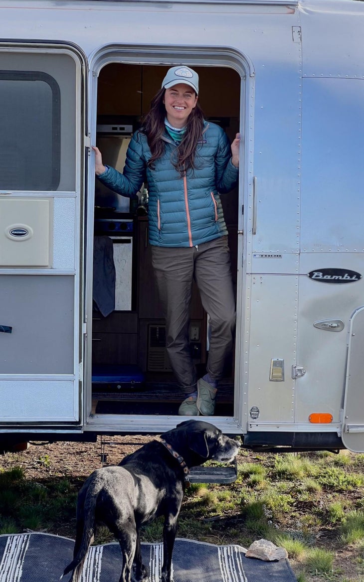 Woman standing in door fram of Airstream trailer. 