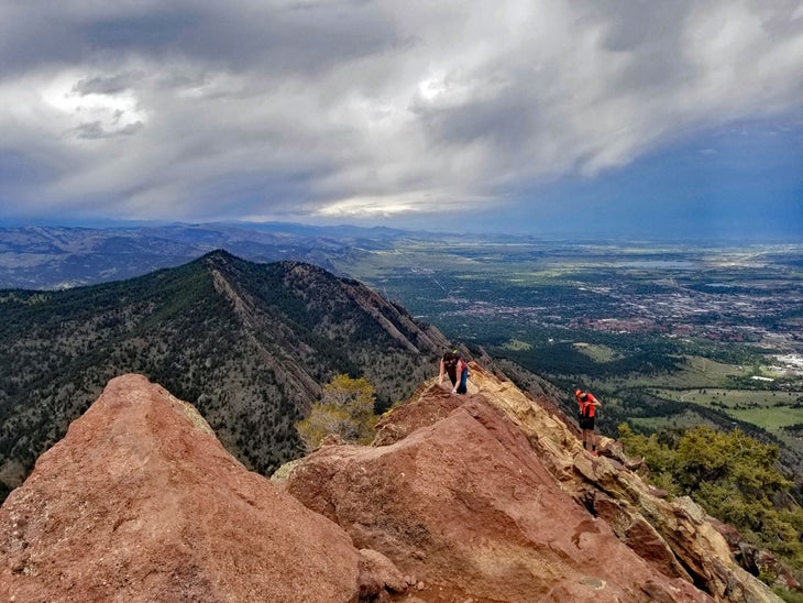 Bear Peak summit in Boulder with city of Boulder below on a cloudy day. 