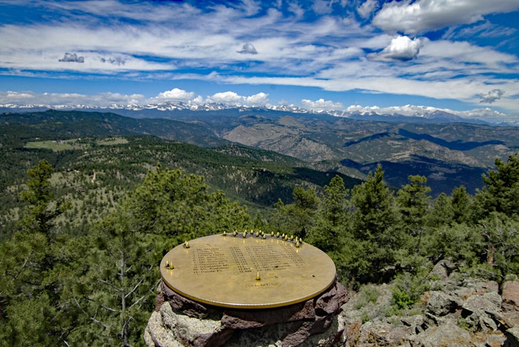 Metal disc atop Green Mountain with peaks in the distance.