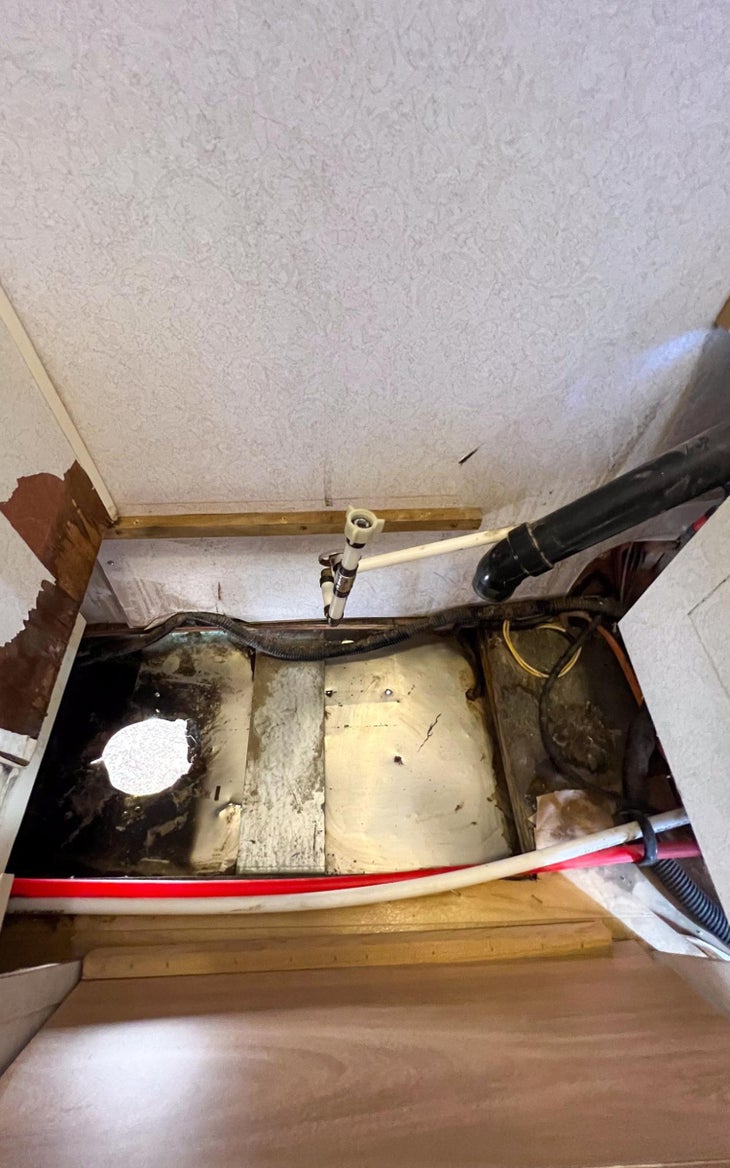 Hole in trailer floor after removing traditional toilet and black tank. 