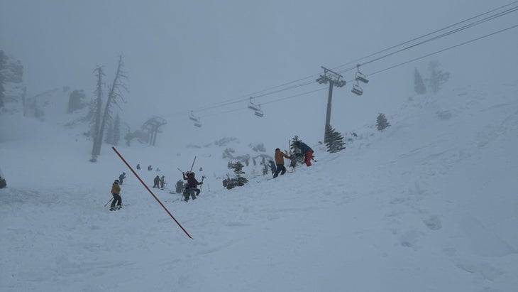 Skiers probe the snow for survivors of an avalanche.