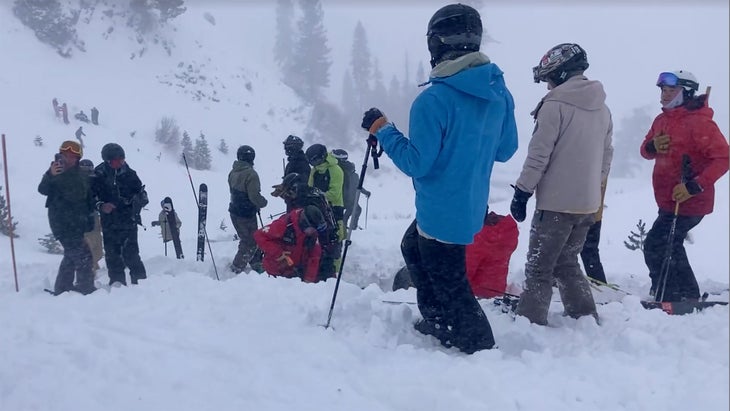 Skiers dig out a survivor of an avalanche at Palisades Tahoe resort. 