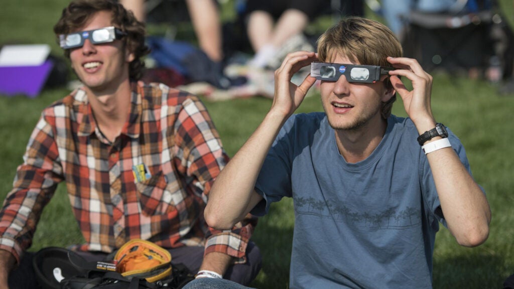 two outdoorsy men watch the eclipse in 2017