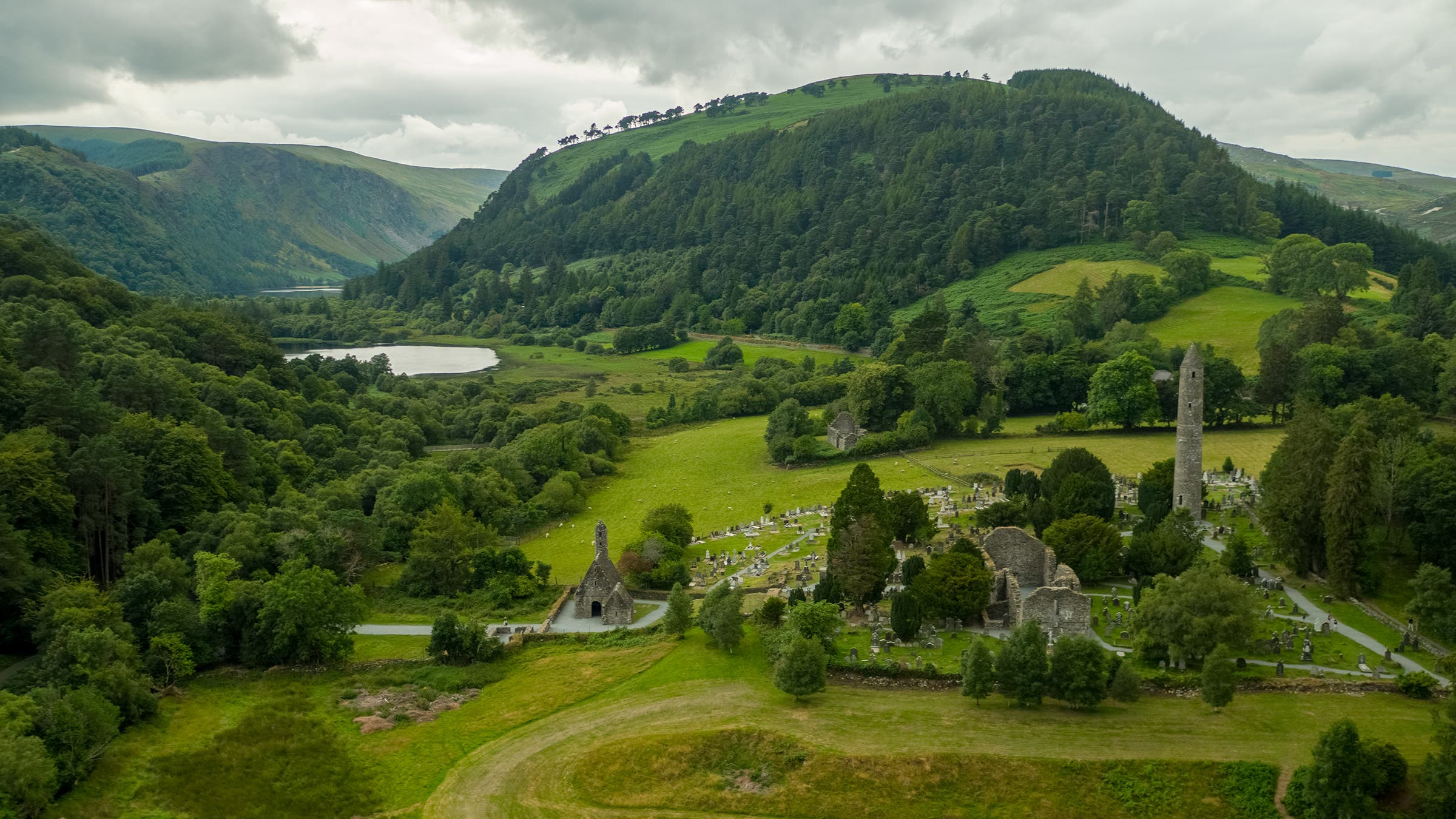 The green hills of Ireland's “Monastic City” in Glendalough beckon trekking travelers.