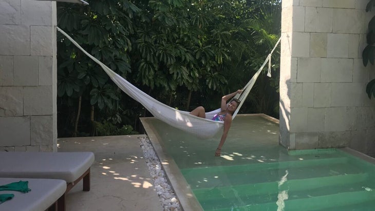 Travel advice columnist Jen Murphy relaxes in a hammock above a pool in Tulum, Mexico.