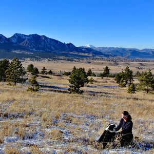 Woman with dog in front of mountains in Boulder, Colorado.