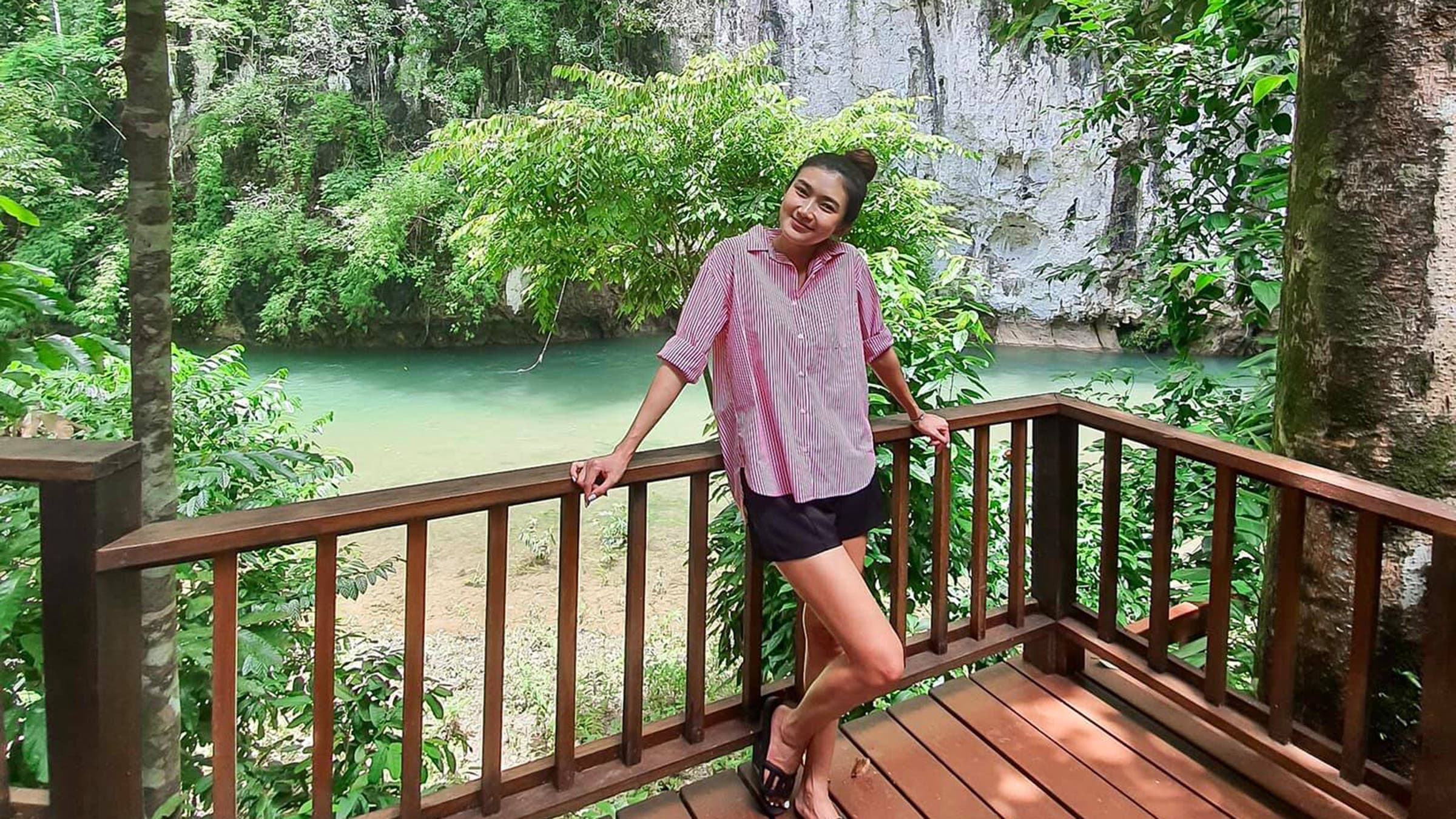 A woman poses on the dek of the treehouse accommodation at Our Jungle House in Thailand.