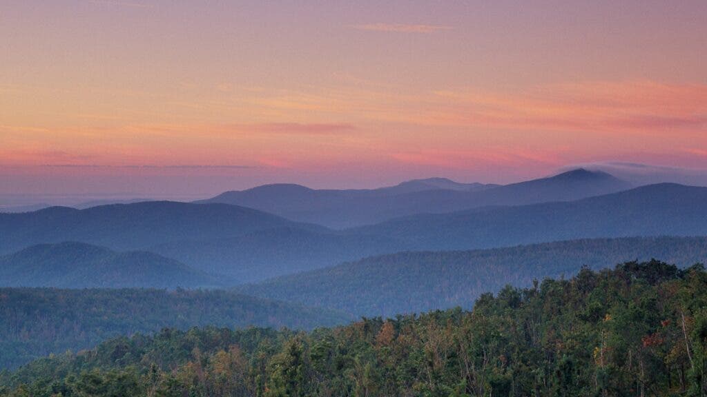A sunset of all the colors of blush illuminates the horizon of Shenandoah National Park, Virginia.
