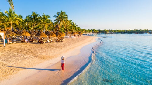A woman walks a beach in the Mexican state of Quintana Roo, home to Tulum. Spring-break-goers have been warned of crime in both tourist and non-tourist areas of this region.