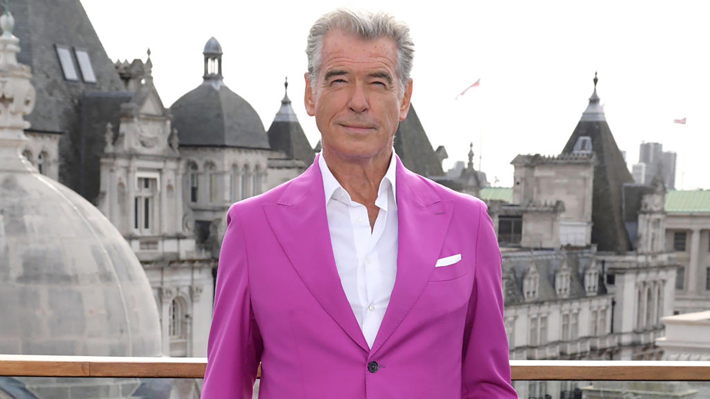 Pierce Brosnan wearing a pink suit.