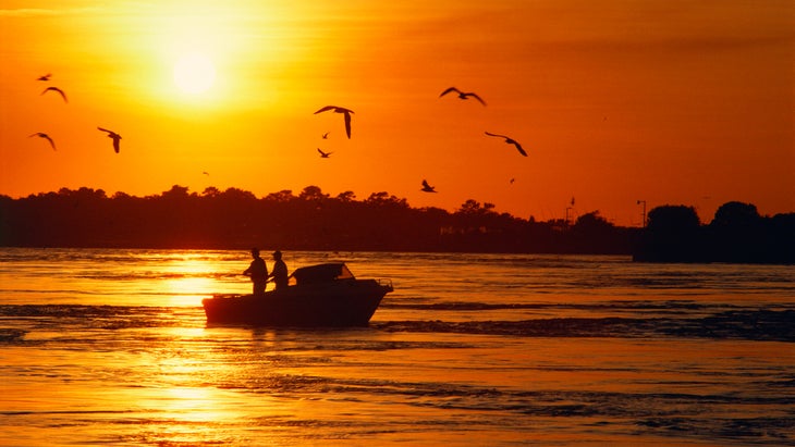 two men fishing at sunset at Indian River inlet, Seashore State Park, Delaware