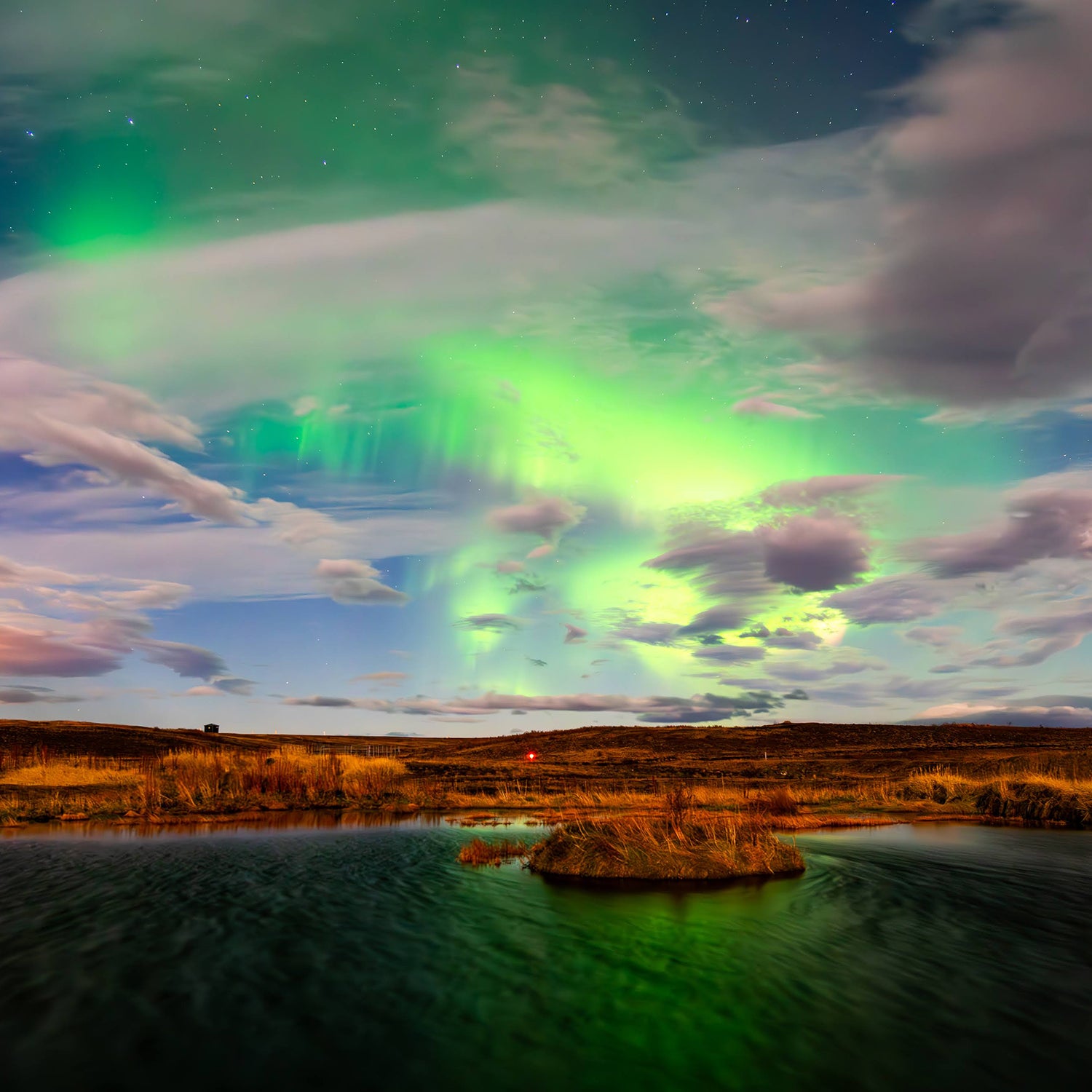 The Northern Lights reflecting off a pond behind the Hotel Rangá on Iceland’s south coast