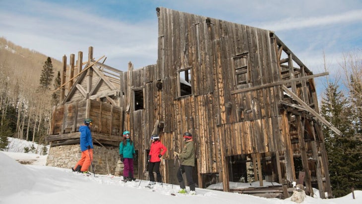 Four skiers pause in front of an old silver mine near Park City, Utah.