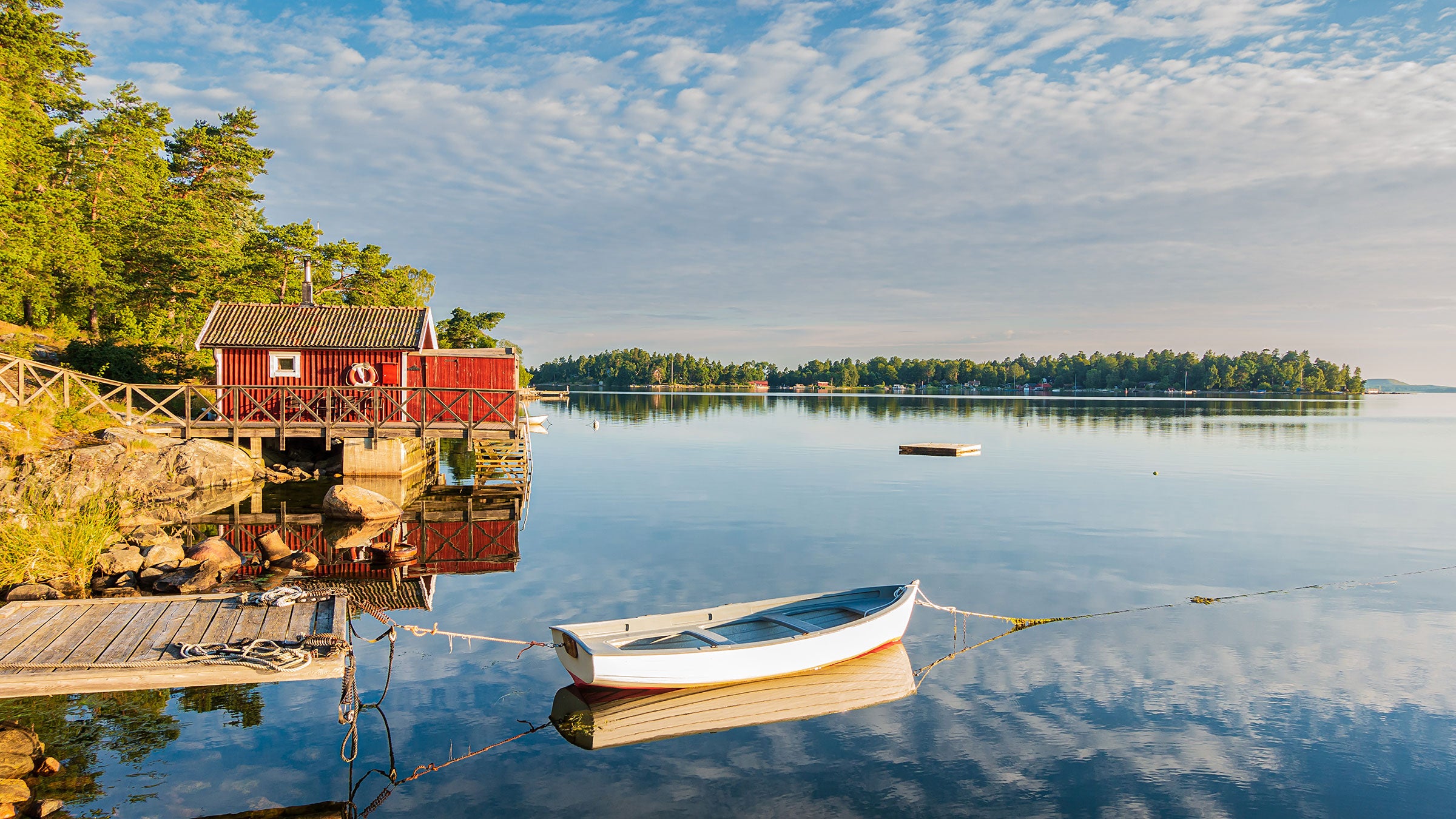 red house in sweden with a boat