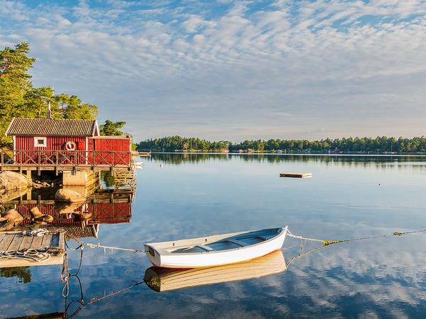 red house in sweden with a boat