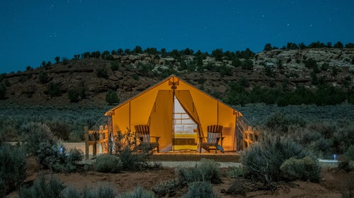 A glowing canvas glamping tent set amid a southwestern landscape near Kanab, Utah.