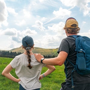 A father and daughter outside on a camping trip.