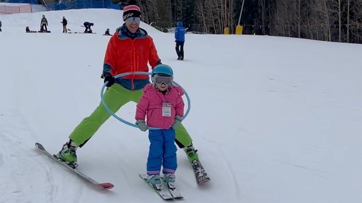 A dad and his daughter skiing
