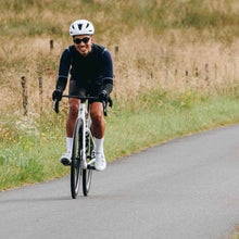 Black Factor Ostro Vam road bike stated on road with trees in background
