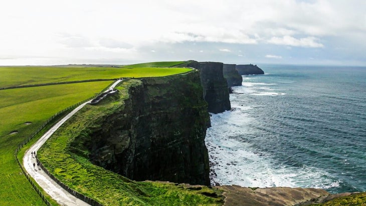Green grass and a winding Cliff Path mark Ireland’s Cliffs of Moher. 