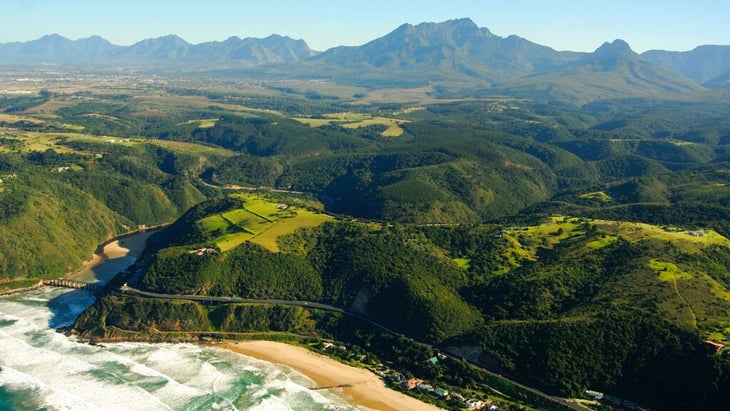 An aerial view of the South Africa’s Western Cape that takes in the Indian Ocean, Garden Route, and Outeniqua Mountains. 