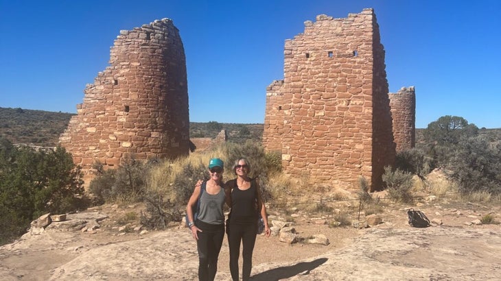 The author and her mother posing in front of Indigenous ruins at Canyons of the Ancients National Monument, Colorado