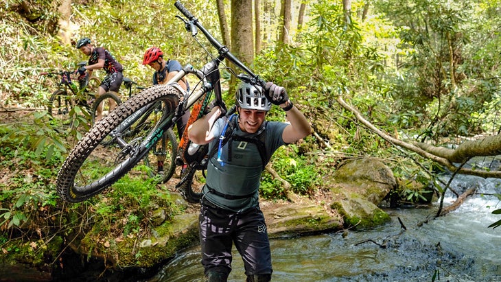 Man holding bike up during Mountaintown Creek Crossing