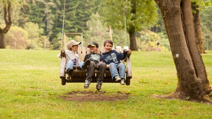 three little boys on a swing at river lodge in Oregon