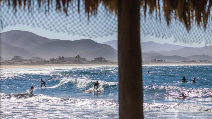 A handful of surfers at Los Cerritos Beach catch small waves. The swell and breaks here accommodate a variety of ability levels.