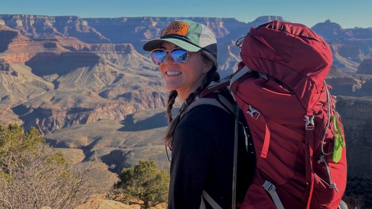 The author posing with her backpack in front of the Grand Canyon