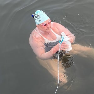 A female swimmer prepares to swim across a stretch of the Pacific Ocean.