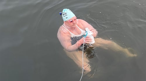 A female swimmer prepares to swim across a stretch of the Pacific Ocean.