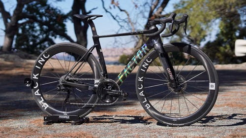 Black Factor Ostro Vam road bike stated on road with trees in background