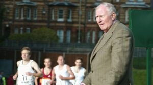 Roger Bannister rings the bell for the last lap at a track race