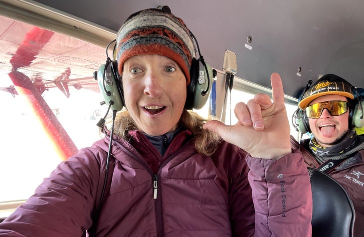 Robbi Mecus poses for a selfie while wearing sound-canceling headphones, with a coworker in the background.