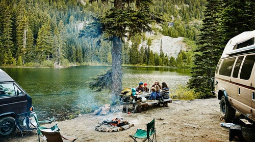 Campers enjoy dinner by the lakeside.