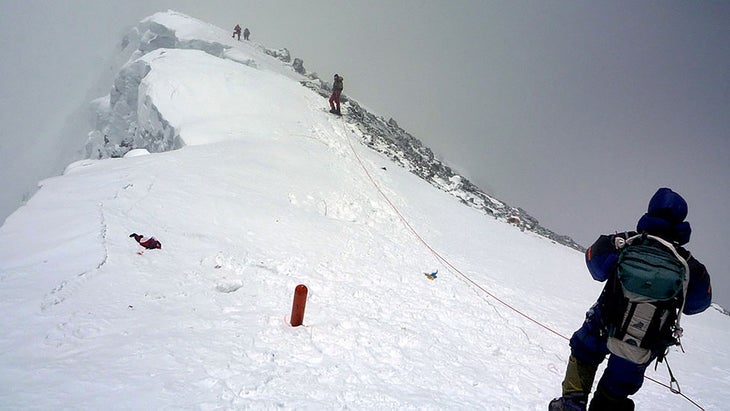 Climbers stand on the sheer edge of Mount Everest.