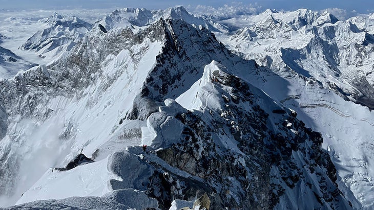 Climbers walk along the exposed ridge on Mount Everest.