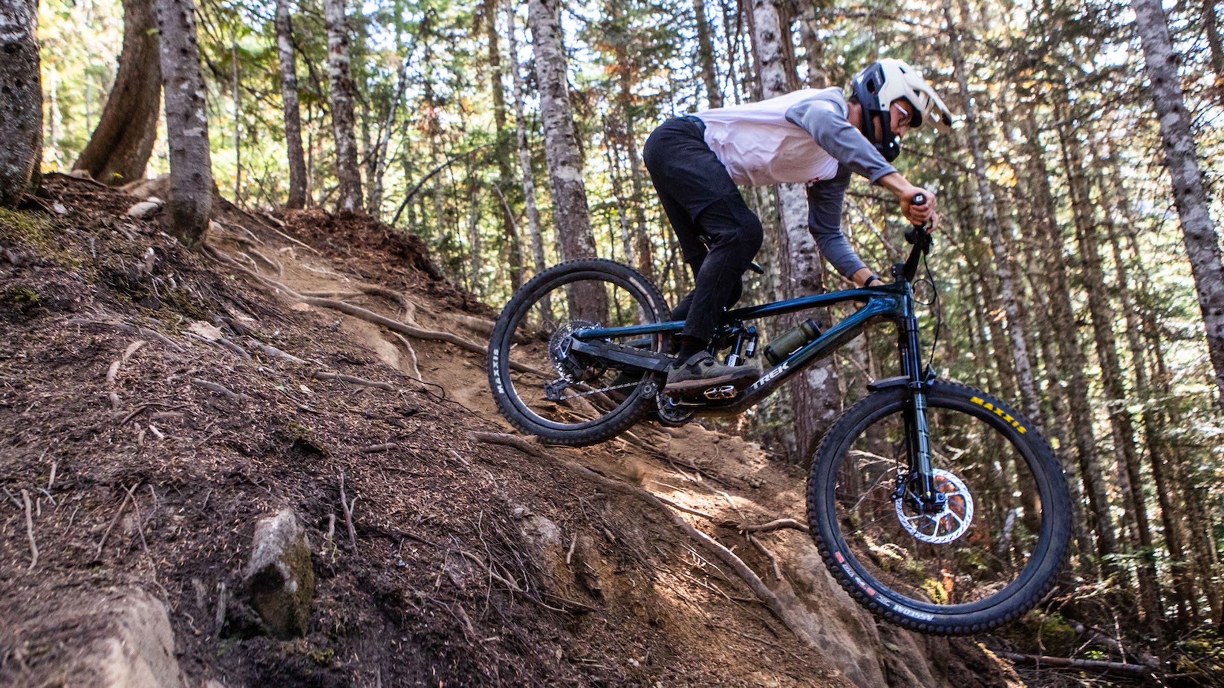 Male rider on Trek Slash enduro bike on dirt single track trail in woods