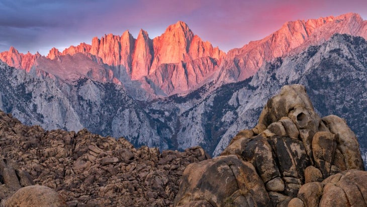 Alpenglow turns the top section of Mount Whitney, California, pink and purple.