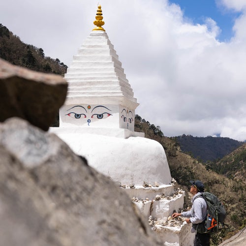 Ang Pemba stacking stones on a stupa near the village of Deboche