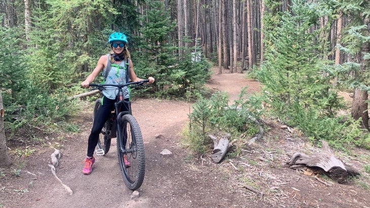 Author Jen Murphy stops while mountain biking in the woods of Breckenridge, Colorado, for a photo.