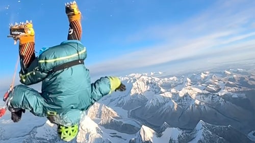 A climber does a backflip on top of Mount Everest