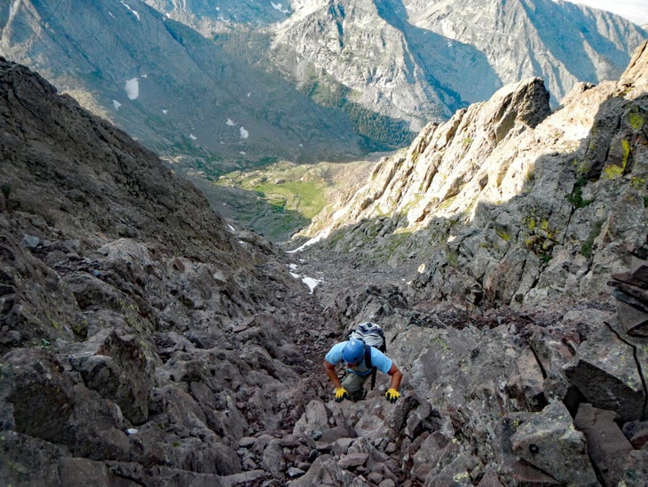 Man scrambling up mountain gully